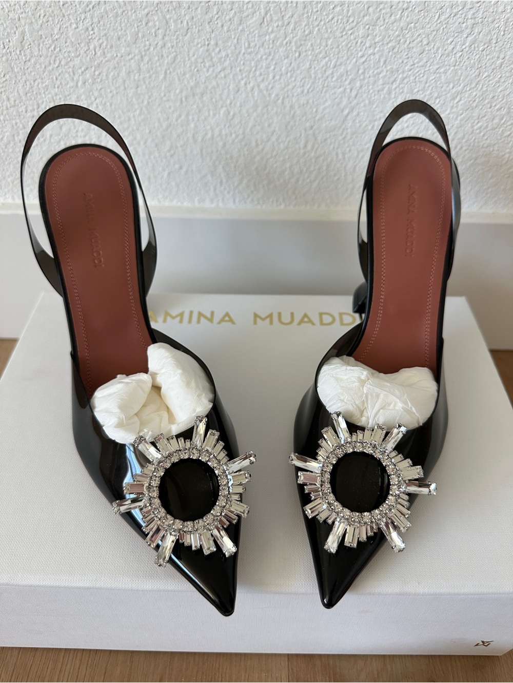Amina Muaddi Black Patent Slingback Pumps with Crystal Sunburst Accents